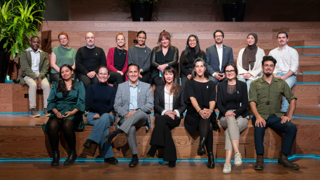 Some of the members of the One Drop team sit next to each other and pose for a team photo.